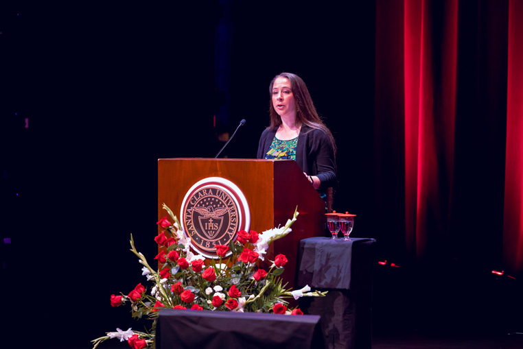 Speaker at a podium with floral decorations