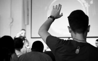 student raising his hand in a classroom 