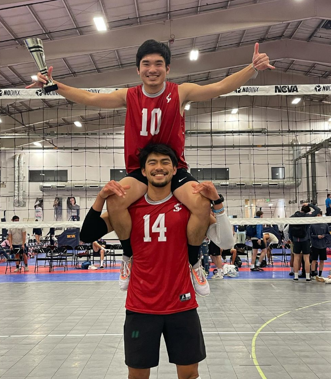 Picture shows two volleyball players. One is on the other's shoulders.