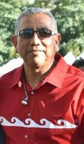 Man in a red shirt with white decorative patterns, wearing sunglasses.