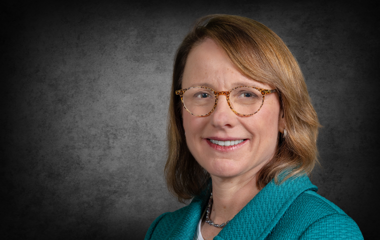 tightly cropped image of a woman in front of a dark gray background