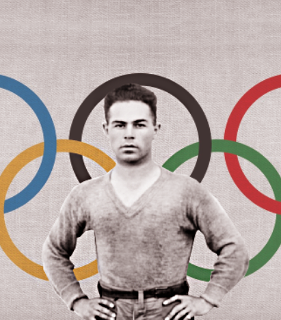A black and white photo of a man standing in front of the Olympic rings in color