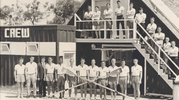 A black and white photo of a group of young men in front of a building labeled 'Crew' 