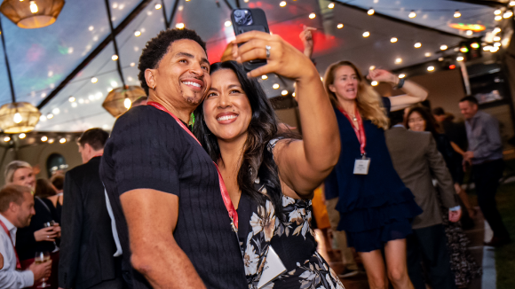 A smiling man and woman taking a selfie on a dance floor.