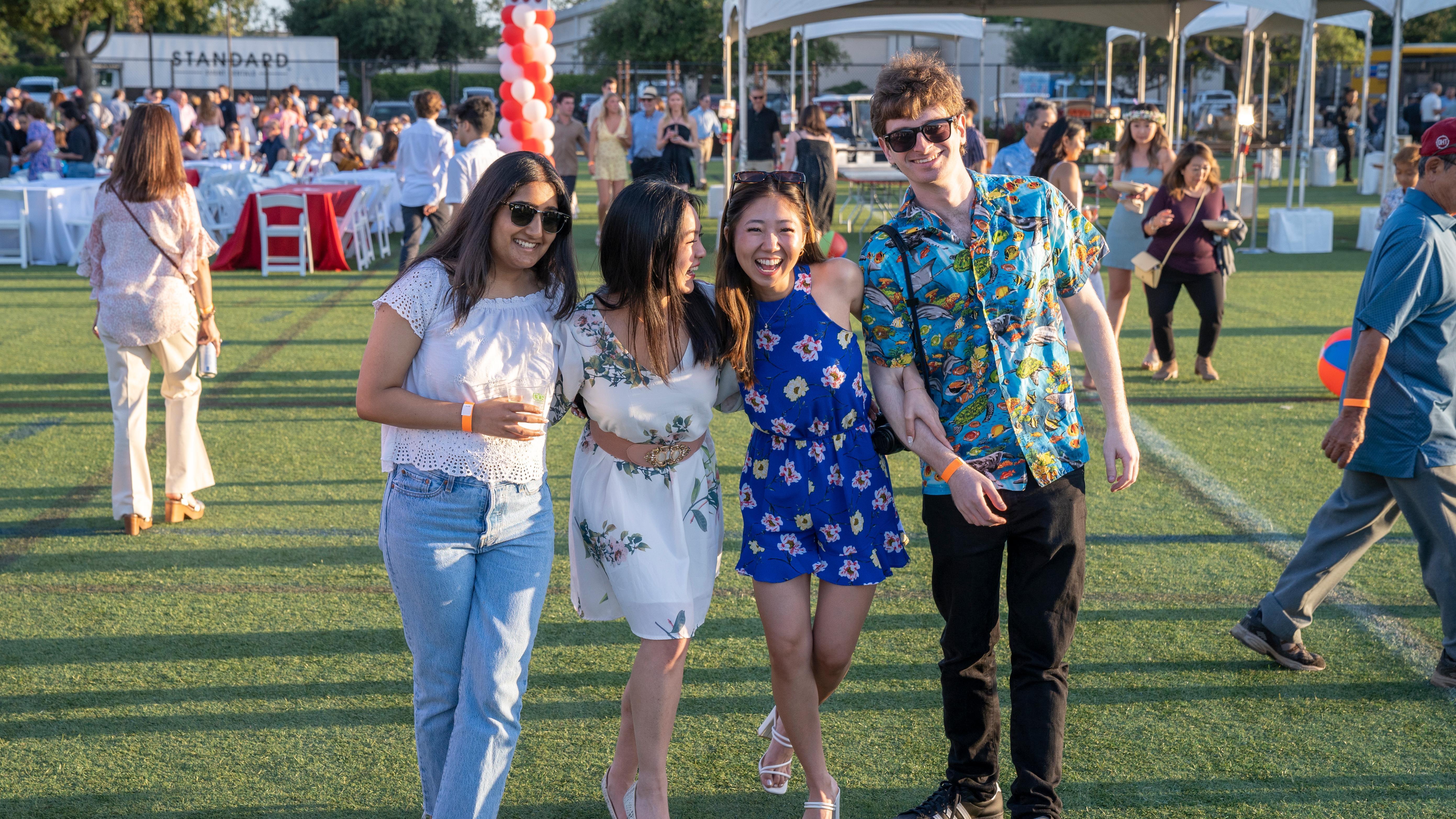 Four alumni walking toward the camera at grad bash 