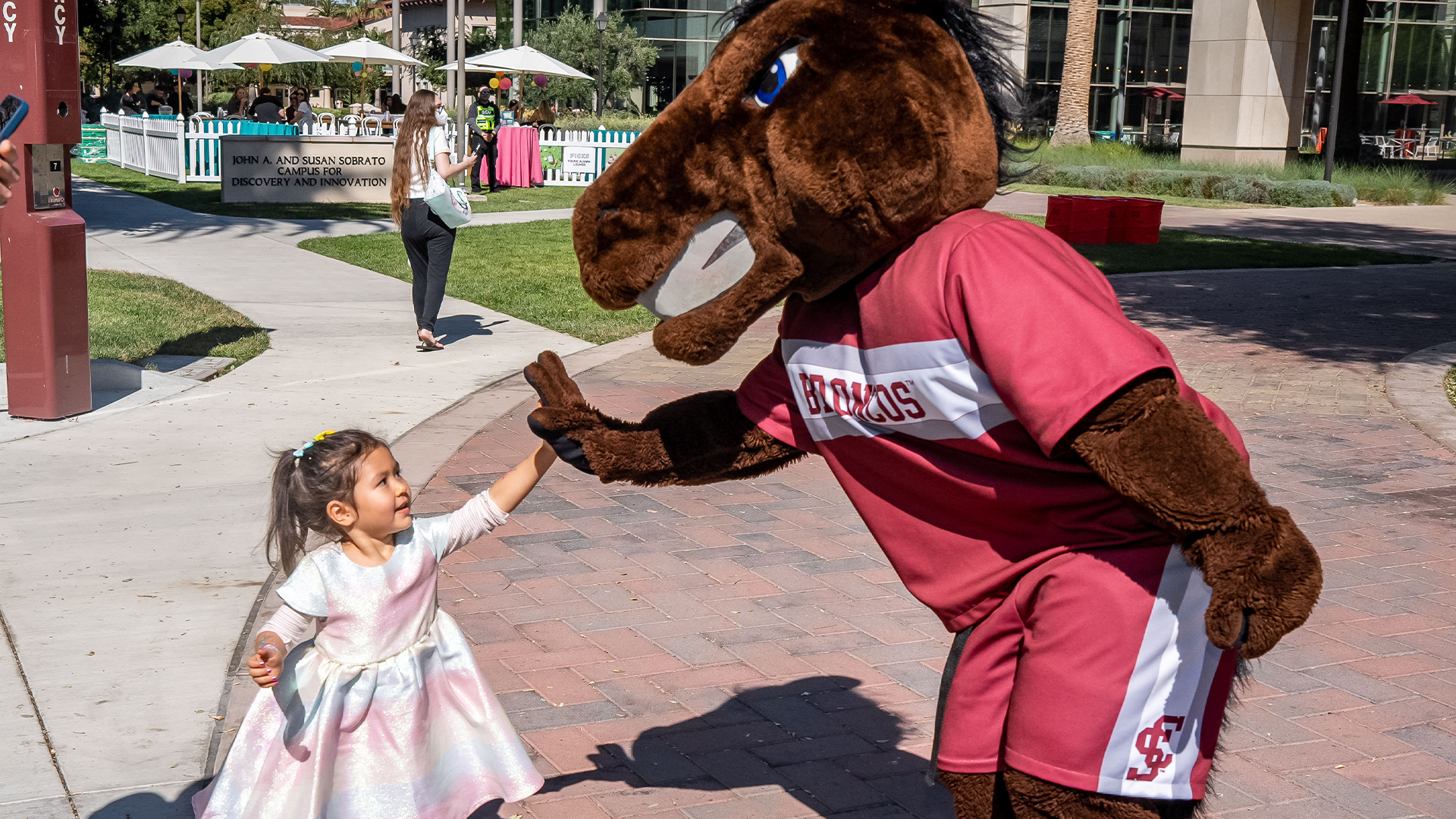 a young child high fiving bucky bronco