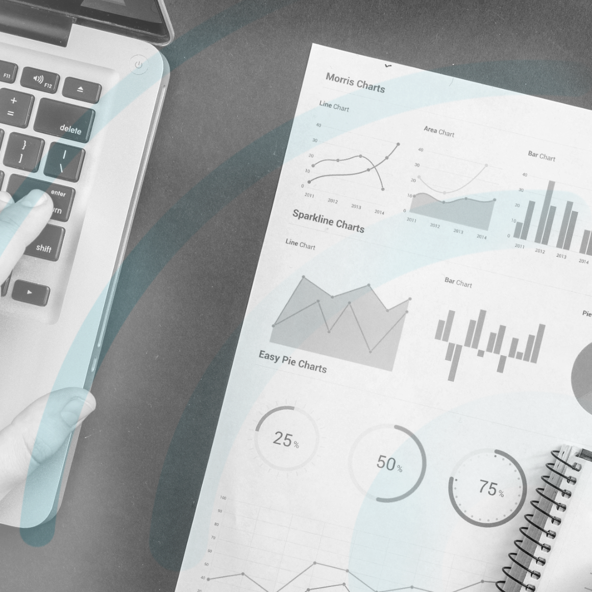 Hand hovering over laptop keyboard, printed out chart with data and graphs