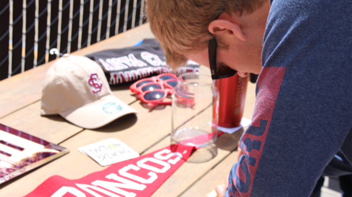 Man crouched over a table of SCU paraphernalia 