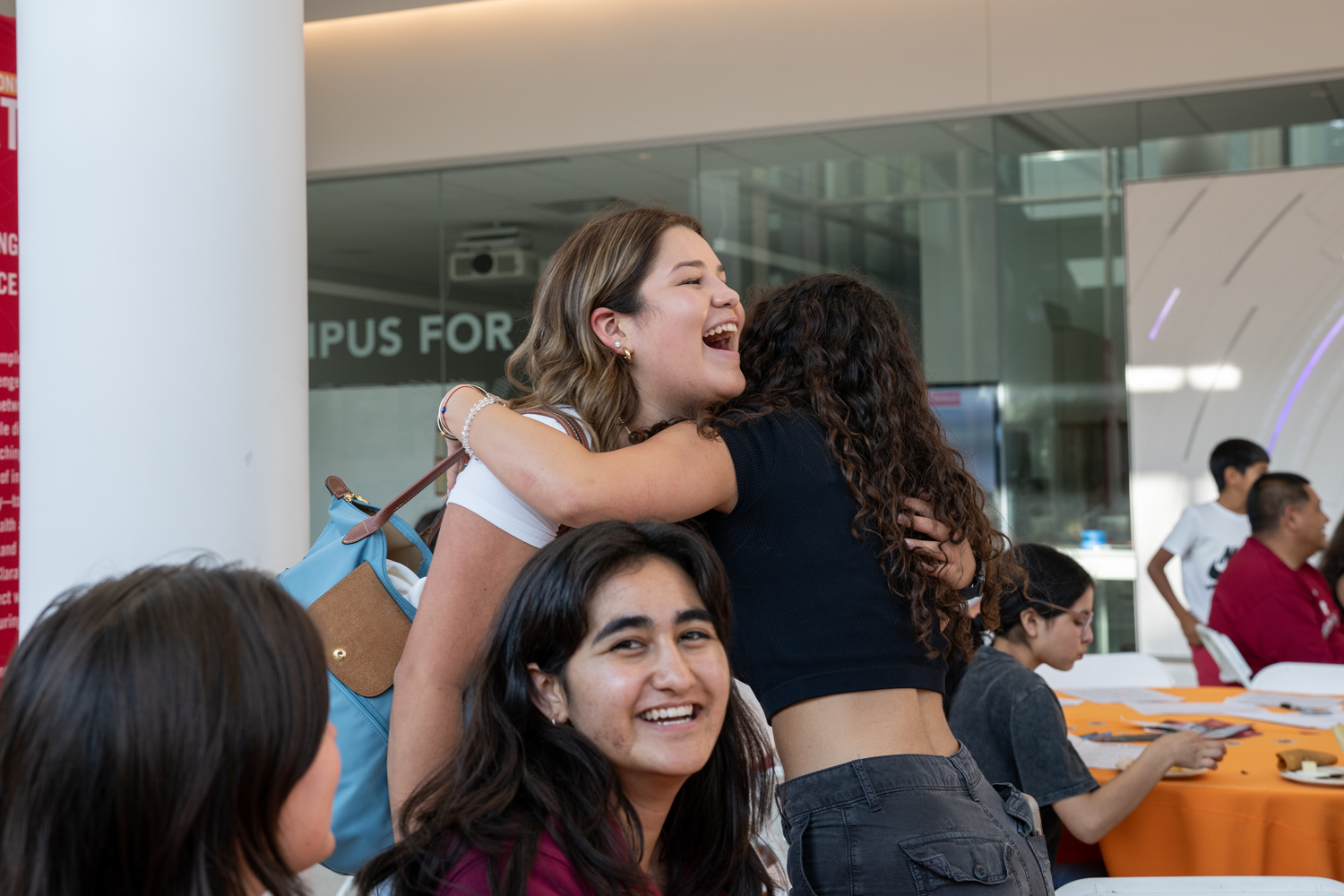 Two alumnae hugging at an airport