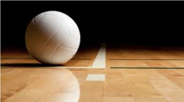 A volleyball on a wooden indoor court. 