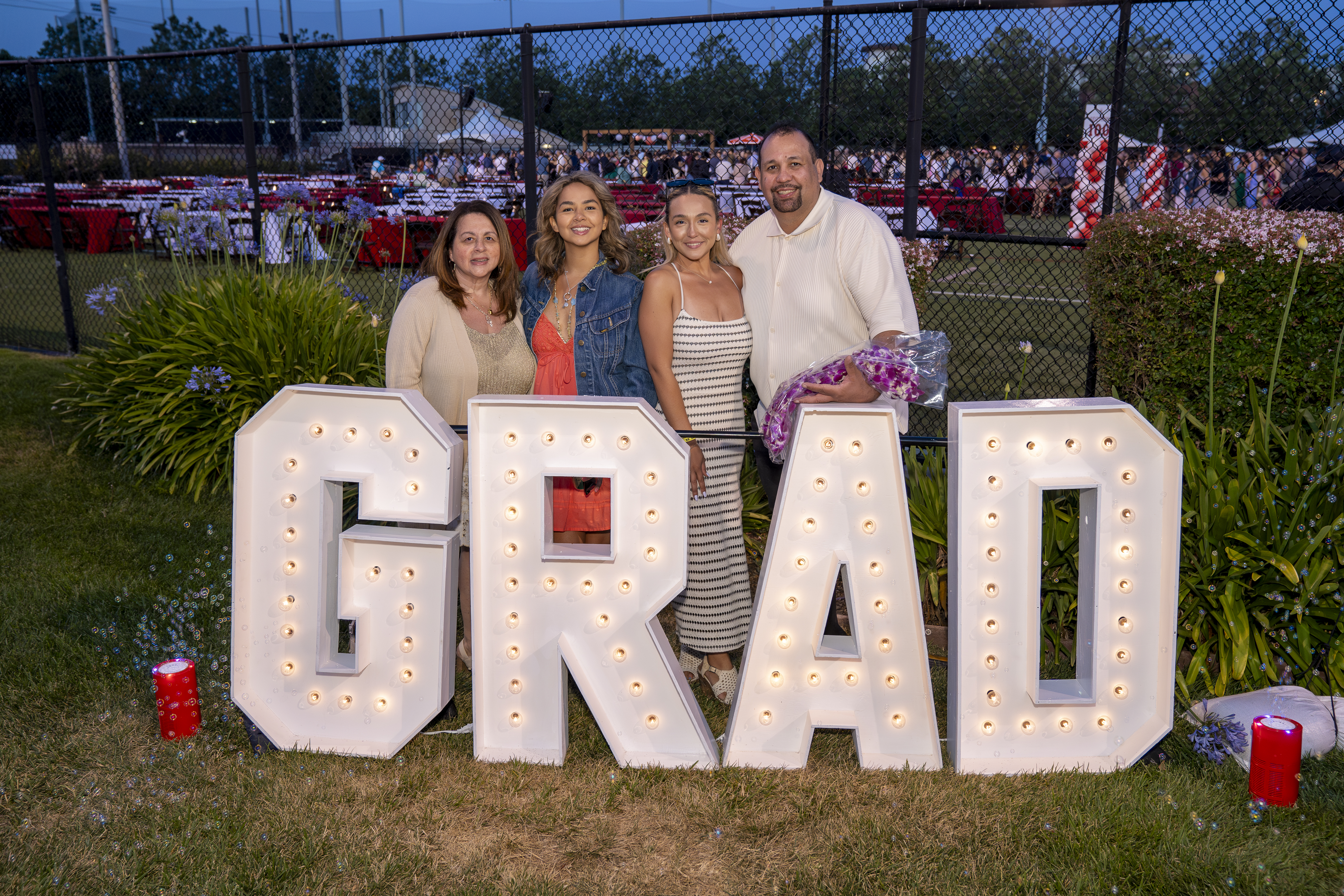 Family photo at GRAD sign at Grad Bash 2024