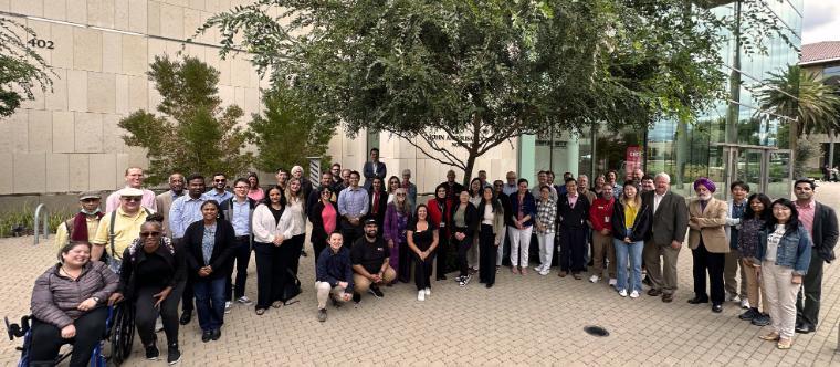 The faculty and staff of the School of Engineering stand as a group in front of the SCDI building.