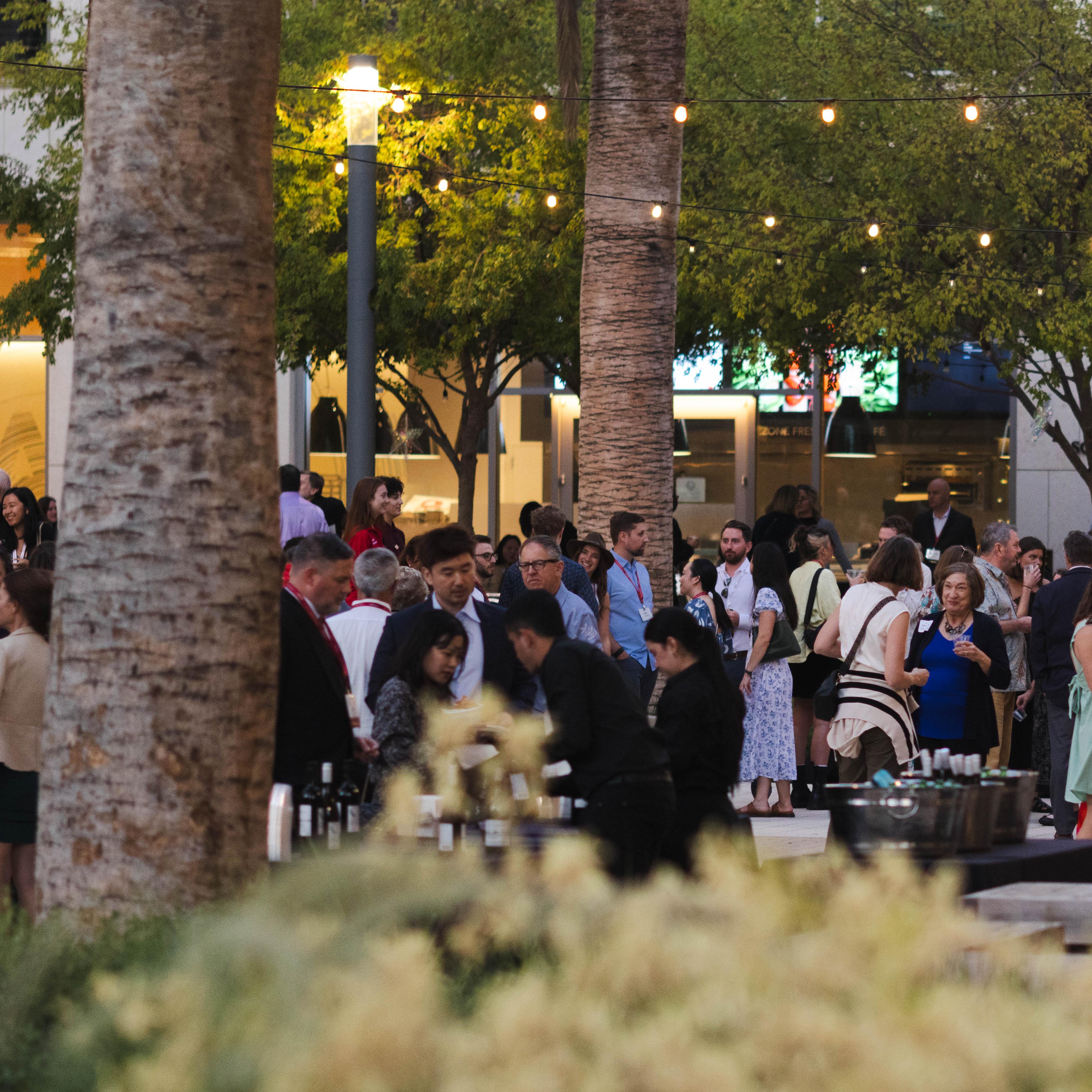 A group of alumni/ae gather in the SCDI courtyard for the 2024 Grand Bash reception.