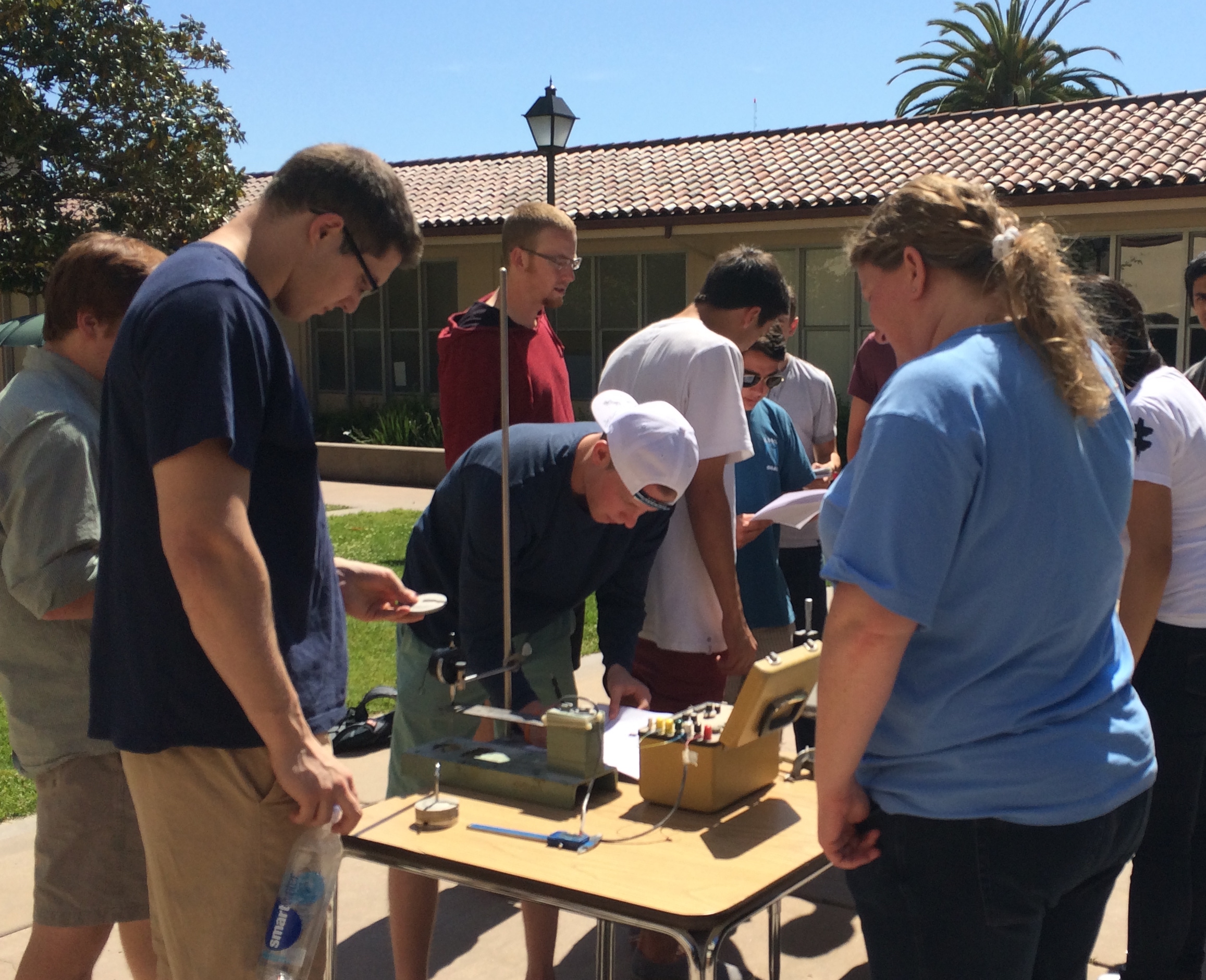 Students and professor working on an experiment in the quad.