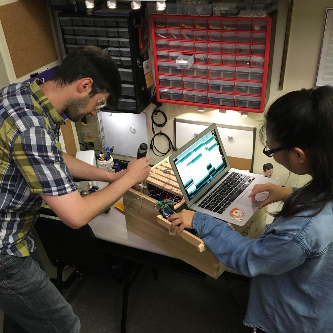 Prof. Navid Shaghaghi and Liying Liang working on assembling sensors in a hive box image link to story
