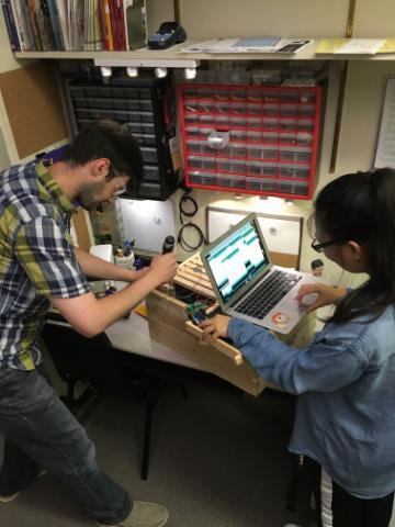 Prof. Navid Shaghaghi and Liying Liang working on assembling sensors in a hive box.