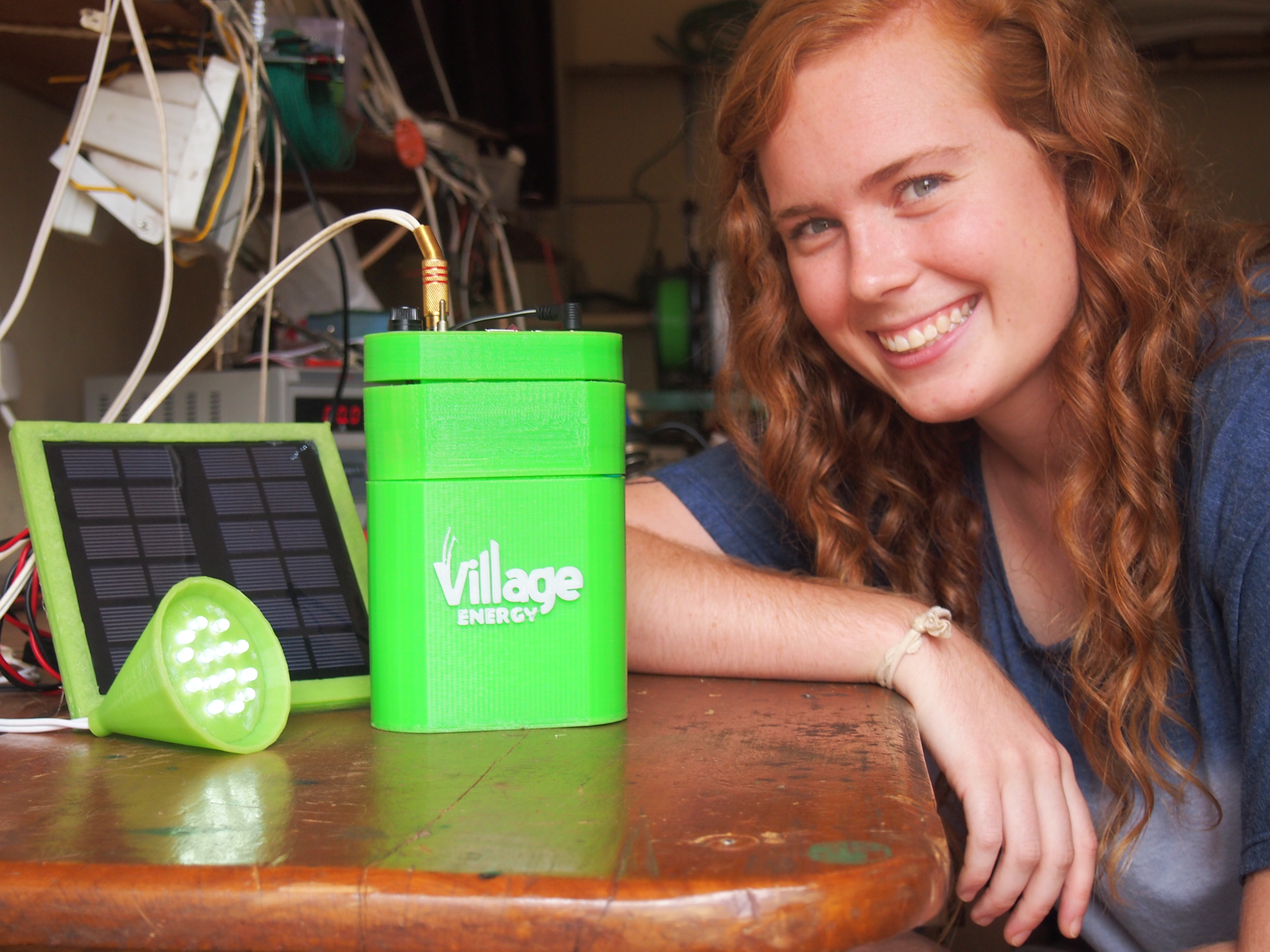 Rachel Wilmoth with the prototype of her 3D printed enclosure for Village Solar's solar panel, battery, and control electronics