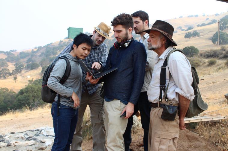 Group of people with backpacks gathered outdoors at HA ranch.