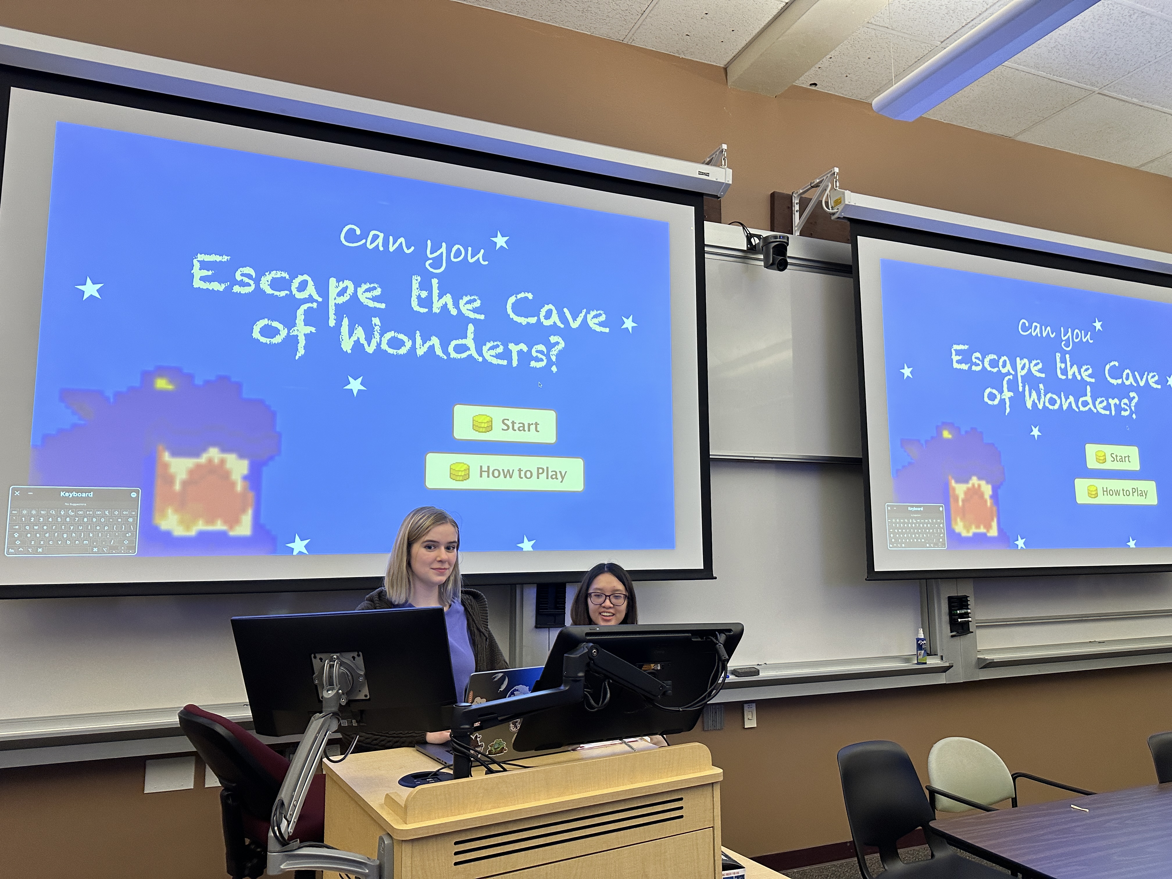 Photo of 2 female ACM student members in front of a projector screen on a classroom.