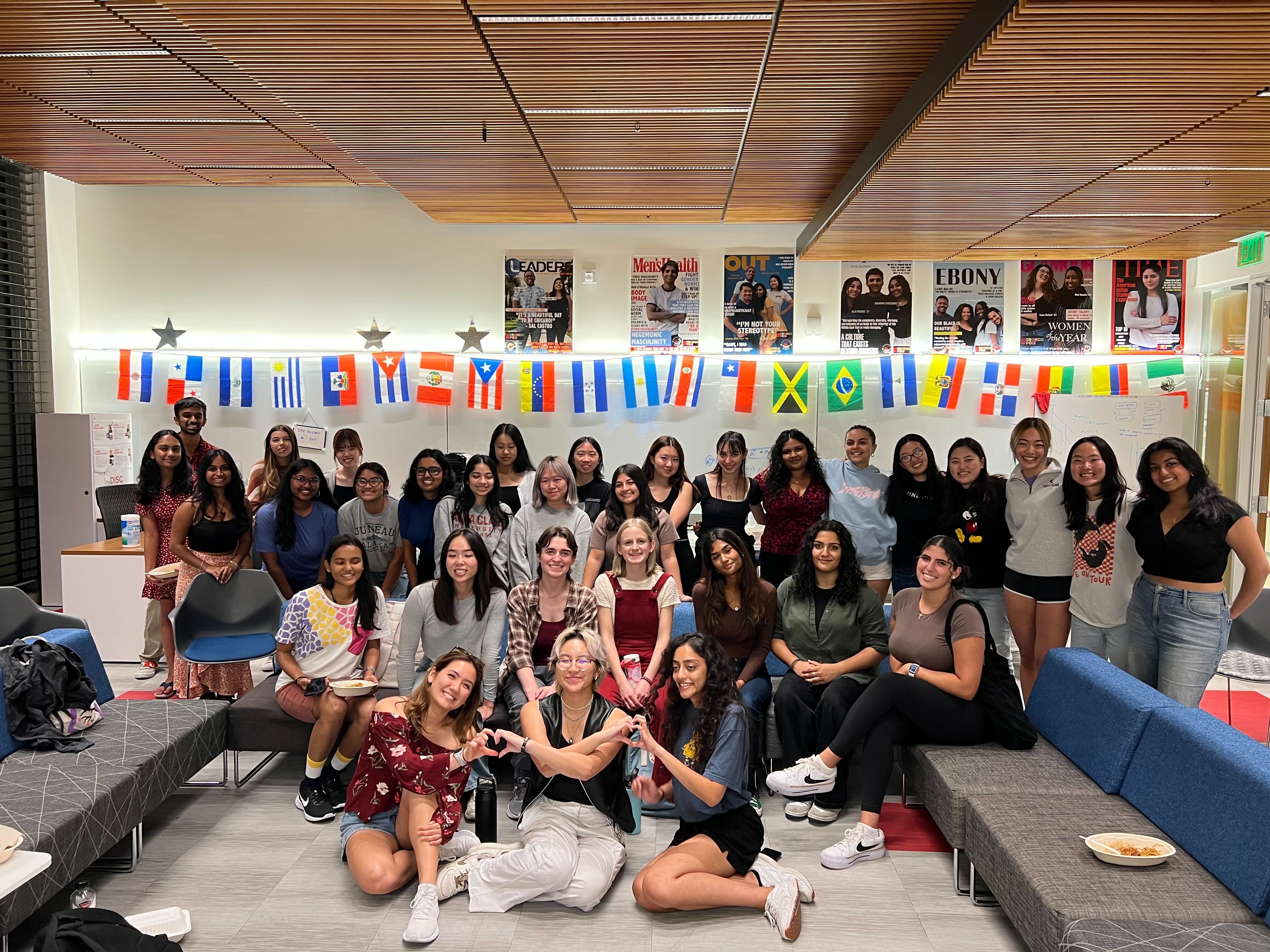 Members of ACM-W posing for a group photos and making hearts with their hands.