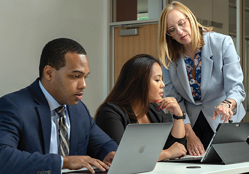 Laura Norris helping students at computer 