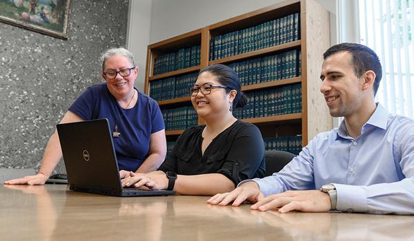 Students on a laptop with instructor 